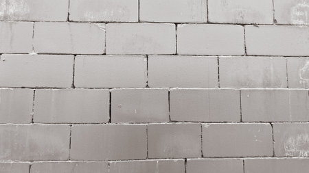 Close-up of a textured gray brick wall, ideal for backgrounds in construction, architecture, or design projects.の写真素材