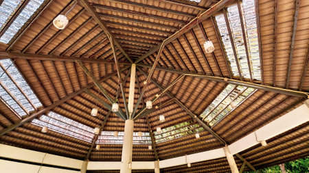 Intricate wooden ceiling with geometric patterns and natural light filtering through glass panels, creating a warm ambiance.の写真素材
