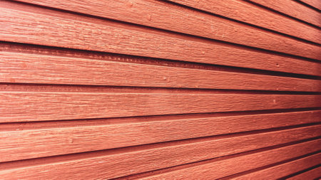 Detailed view of a red wooden wall with horizontal planks, showcasing texture and rustic charm.の写真素材