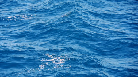 Close-up of vibrant blue ocean waves under sunlight, showcasing the dynamic and serene beauty of the...