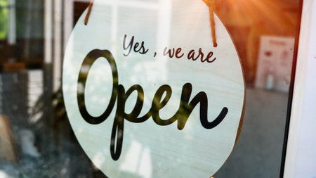 A closeup shot of a glass door with a sign saying we are openの写真素材