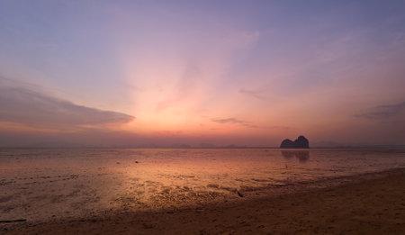 Breathtaking sunset over a calm beach, showcasing vibrant colors and a peaceful atmosphere.の写真素材