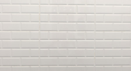 Close-up of a white subway tile wall showcasing a clean, geometric pattern ideal for modern design and architecture.の写真素材