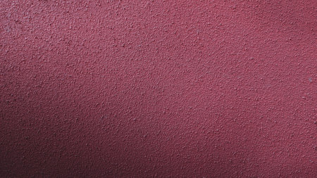 Close-up of a textured red wall, showcasing its rough surface and rich color, perfect for backgrounds or design projects.の写真素材