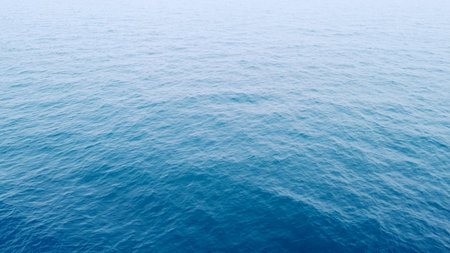 A peaceful view of the ocean's surface with gentle waves, showcasing the vastness and tranquility of the sea.の写真素材