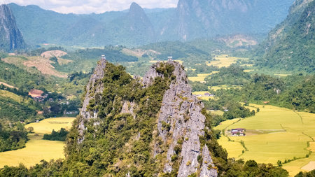 A breathtaking aerial shot capturing limestone peaks surrounded by verdant valleys and fields under a bright blue sky.の写真素材