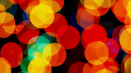 Bright and colorful bokeh background featuring vibrant red, orange, and yellow light circles, perfect for festive and creative designs.の写真素材