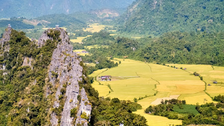 A breathtaking aerial landscape showcasing a vibrant green valley, rugged mountains, and expansive farmland under a clear blue sky.の写真素材