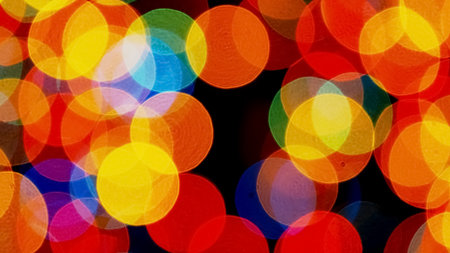 A vibrant abstract bokeh background featuring colorful circles of light in red, yellow, blue, and green hues.の写真素材