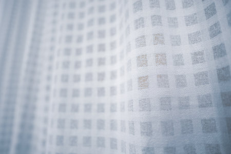 Detailed view of white fabric with a square pattern, perfect for backgrounds or design projects.の写真素材