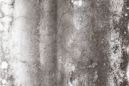 Close-up of a weathered concrete wall showcasing grunge texture and cracks, perfect for backgrounds or design elements.の写真素材