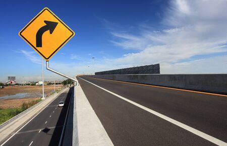 curve road sign with blue sky