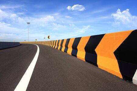 curve road sign with blue skyの写真素材