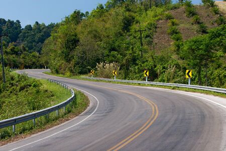 Curve road sign on down hill 