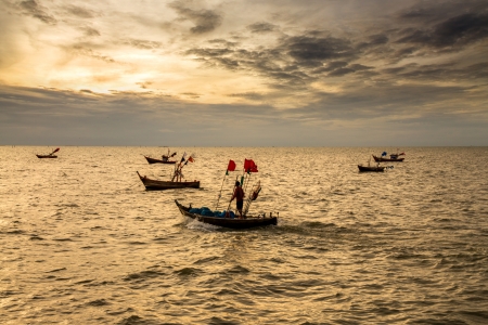 Fishing boat and fisherman in sunsetの写真素材