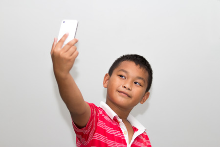 Little kid taking a selfie with cell phoneの写真素材