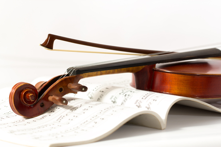 Close up of a violin and bow on book music backgroundの写真素材