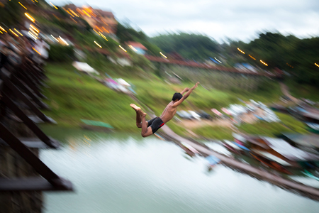 Young boy jumping into riverの写真素材