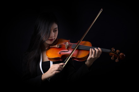Playing the violin. Musical instrument with hands on dark background.の写真素材