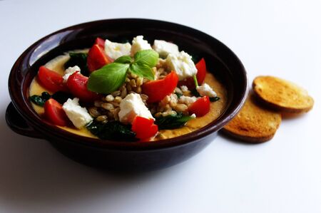 Healthy Meals: barley soup in a bowl with chick peas, spinach, feta cheese, cherry tomatoes, basil...