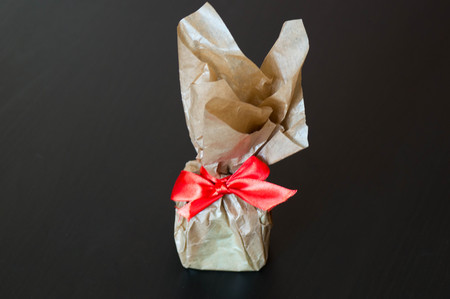 Gift box wrapped in brown minimal paper with red ribbonの写真素材