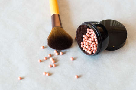 Scattered makeup powder, highlighter beads with a big makeup brushの写真素材