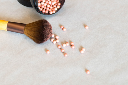 Makeup brush with highlighter beads on a white backgroundの写真素材