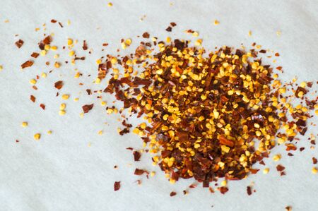 Close up view of red chili flakes on white backgroundの写真素材