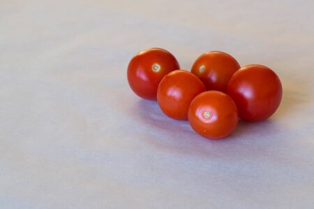 Five pieces of red cherry tomatoes on white backgroundの写真素材