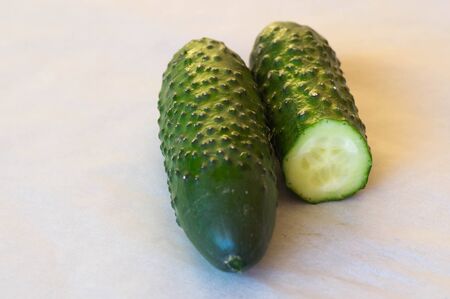 One whole and one half cucumber on white backgroundの写真素材
