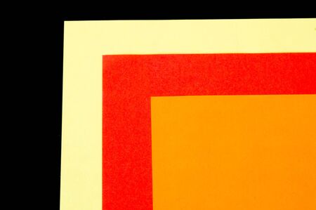 Three overlapping coloured papers isolated on blackの写真素材