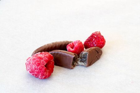 three pieces of frozen raspberry fruit with two pieces of jelly filled chocolate