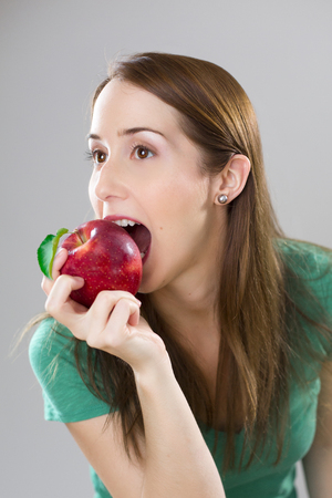 Healthy woman eating appleの写真素材