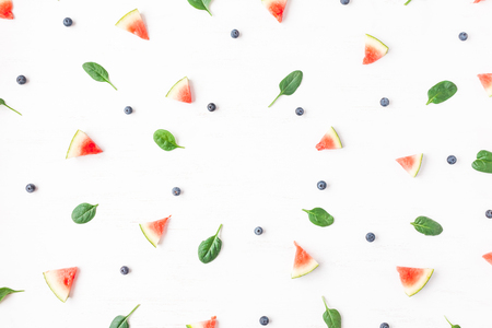 Watermelon slices, blueberry and spinach leaves on white background. Summer concept. Flat lay, top viewの写真素材