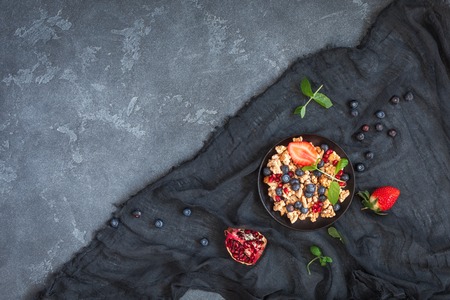 Healthy breakfast with muesli and berries on stone background. Flat lay, top viewの写真素材