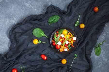 Spring salad with arugula, feta cheese, bell pepper and cherry tomatoes. Flat lay, top viewの写真素材