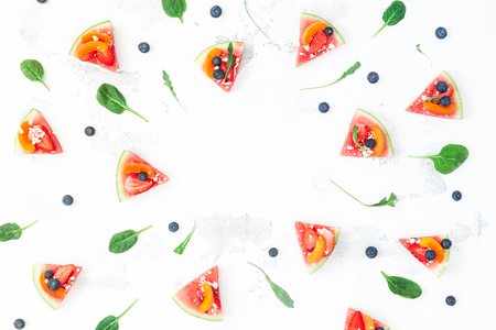 Sliced fruit pizza made of watermelon, strawberry, blueberry, apricot. Fruit frame. Flat lay, top viewの写真素材