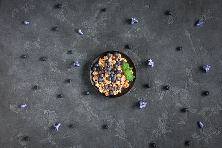 Healthy breakfast with muesli and berries on black background. Flat lay, top viewの写真素材