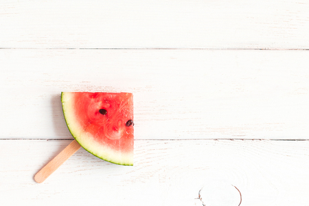 watermelon slices on sticks on wooden white background, flat lay, top viewの写真素材