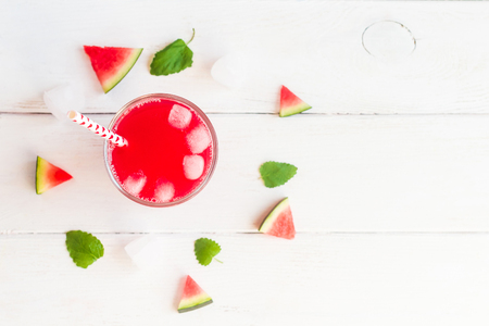 watermelon juice and watermelons slices on wooden white backgroundの写真素材