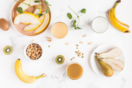 Fresh smoothie with pear, banana, melon, kiwi. Summer fruit cocktail on white table. Vegan, vegetarian, detox, dieting concept. Flat lay, top viewの写真素材