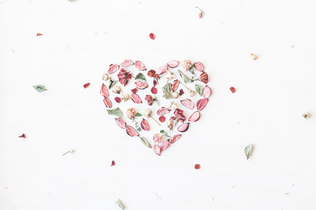 Flowers composition. Heart symbol made of dried flowers and leaves. Top view, flat layの写真素材