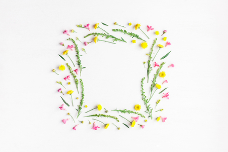 Flowers composition. Frame made of yellow and pink flowers on white background. Flat lay, top viewの写真素材
