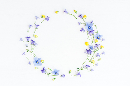 Wreath made of bell flowers, pansy flowers and yellow flowers on white background. Flat lay, top viewの写真素材