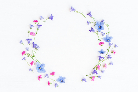 Wreath made of bell flowers, pansy flowers and pink flowers on white background. Flat lay, top viewの写真素材