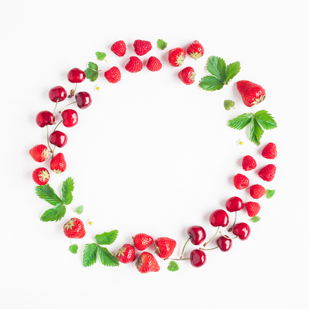 Fruits on white background. Creative frame made of fresh fruits. Strawberry, raspberry, blueberry and sweet cherry. Summer concept. Flat lay, top view, copy spaceの写真素材