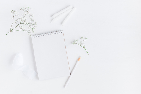 Workspace with notebook, paper blank, gypsophila flowers, pencils. Wedding concept. Flat lay, top view