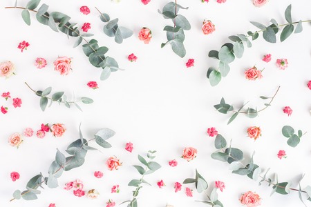 Flowers composition. Round floral frame made of rose flowers and eucalyptus branches on white background. Flat lay, top view, copy spaceの写真素材