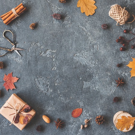 Autumn composition. Gift, autumn leaves, cinnamon sticks, anise stars, pine cones on black...