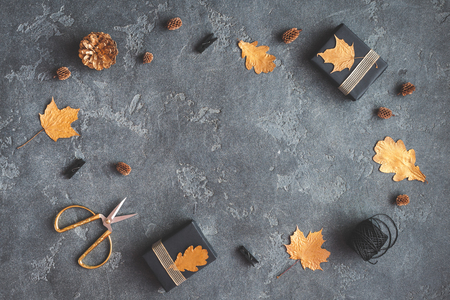 Autumn composition. Gifts, autumn golden leaves, pine cones, accessories on black background. Flat lay, top viewの写真素材